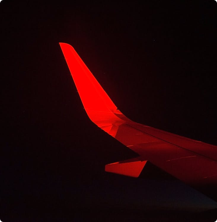 Aile d'avion dans la nuit avec une lumière rouge
